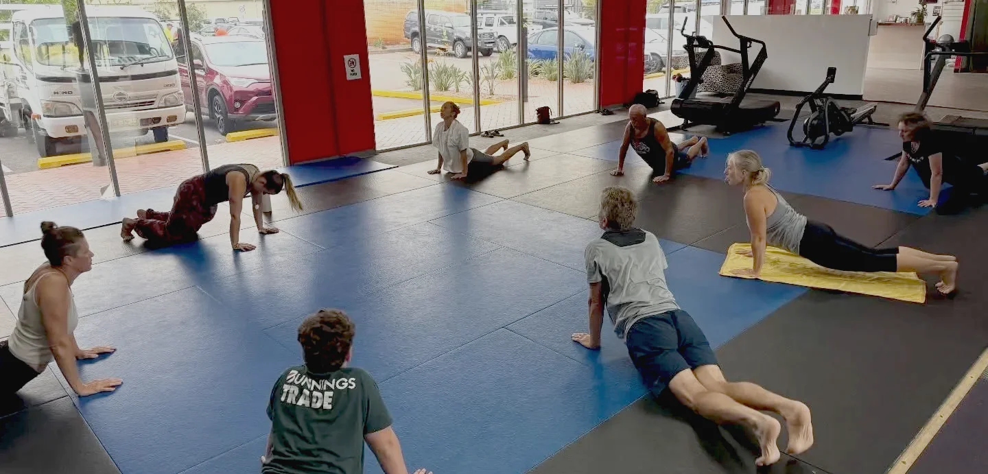Group stretching workshop on the mats at Personal Touch Fitness